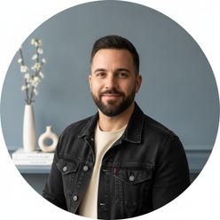 A circular portrait of Tyson Reed, a man with a short beard, wearing a washed black denim jacket and smiling at the camera.